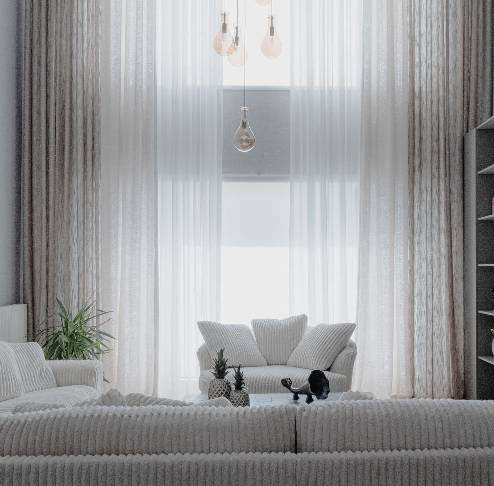 A cluster of warm pendant bulbs hung at staggered heights in a bright modern living room